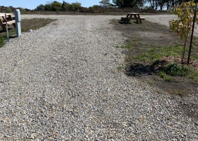 Image of a park with a wide gravel way and sitting benches