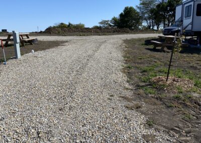 Wide gravel way with a white RV camper